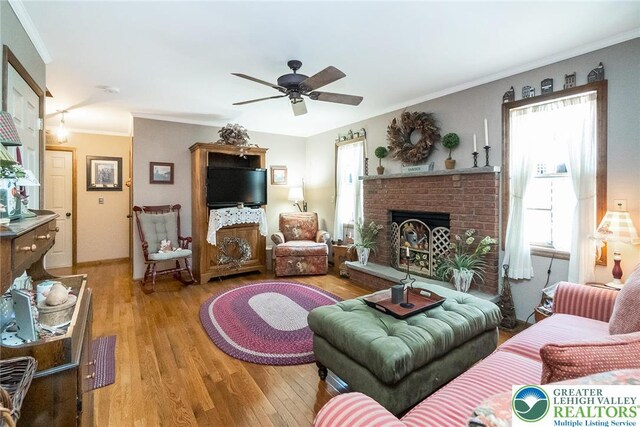 2300 Woodridge Ter, Easton, PA 18045 - living area with light wood-type flooring, ceiling fan, ornamental molding, and a brick fireplace