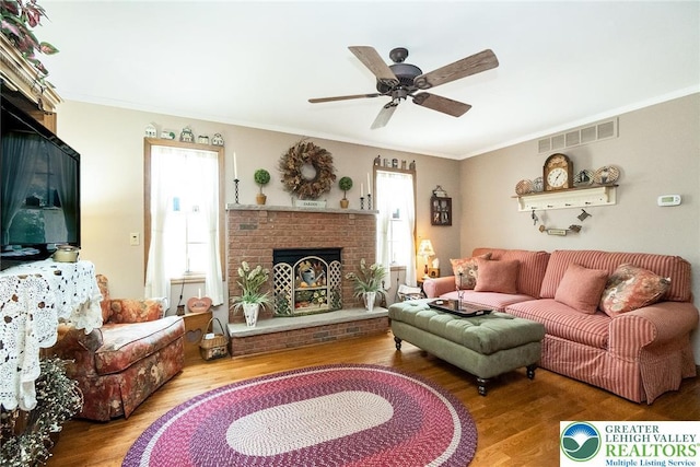 2300 Woodridge Ter, Easton, PA 18045 - living room featuring a brick fireplace, wood finished floors, crown molding, and a ceiling fan