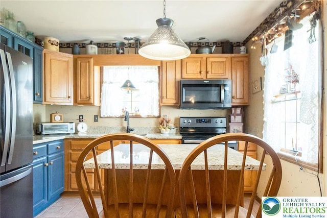 2300 Woodridge Ter, Easton, PA 18045 - kitchen featuring stainless steel appliances, light countertops, blue cabinetry, light tile patterned flooring, and pendant lighting