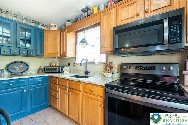 2300 Woodridge Ter, Easton, PA 18045 - kitchen with range with electric cooktop, light tile patterned flooring, light stone countertops, glass insert cabinets, and blue cabinets