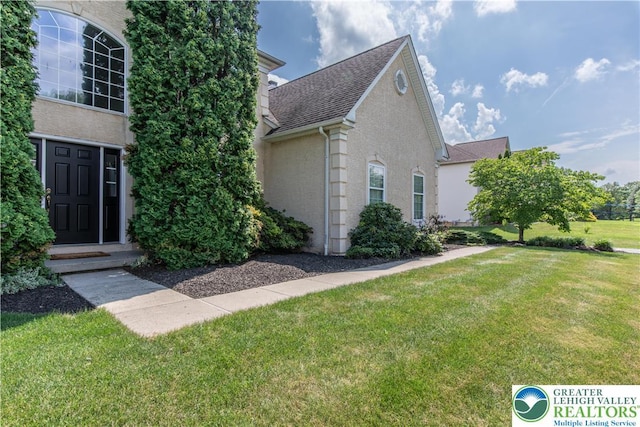 4325 Crosswinds Dr, Easton, PA 18045 - view of front of home featuring a front lawn, a shingled roof, and stucco siding