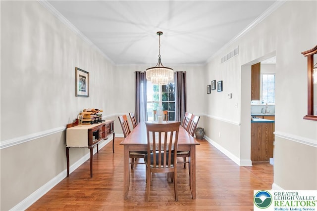 4325 Crosswinds Dr, Easton, PA 18045 - dining area with a chandelier, healthy amount of natural light, light wood finished floors, and ornamental molding