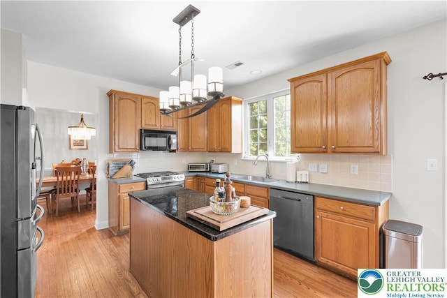 4325 Crosswinds Dr, Easton, PA 18045 - kitchen featuring appliances with stainless steel finishes, light wood-type flooring, a center island, a chandelier, and backsplash