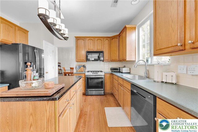 4325 Crosswinds Dr, Easton, PA 18045 - kitchen featuring appliances with stainless steel finishes, light wood finished floors, tasteful backsplash, hanging light fixtures, and a center island