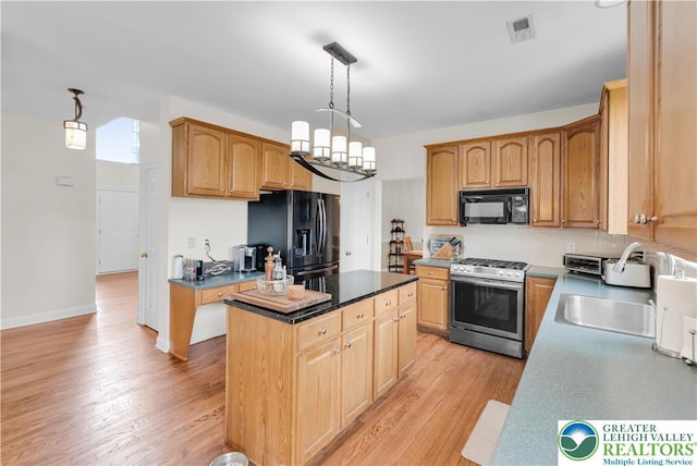 4325 Crosswinds Dr, Easton, PA 18045 - kitchen featuring black appliances, light wood finished floors, a kitchen island, pendant lighting, and dark countertops