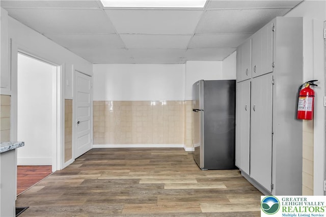 133 S 14th St, Easton, PA 18042 - kitchen with freestanding refrigerator, a drop ceiling, light wood-type flooring, and light countertops