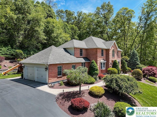1376 Buck Ridge Dr, Hamilton Twp, PA 18360 - view of front facade with brick siding, a garage, driveway, and a shingled roof
