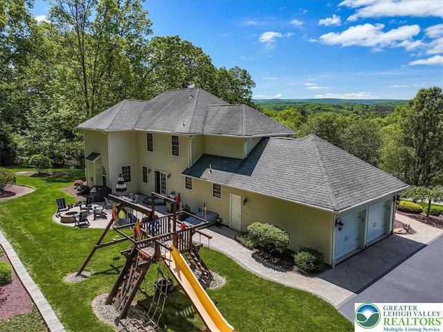 1376 Buck Ridge Dr, Hamilton Twp, PA 18360 - back of property with a lawn, an outdoor fire pit, a playground, roof with shingles, and a patio area