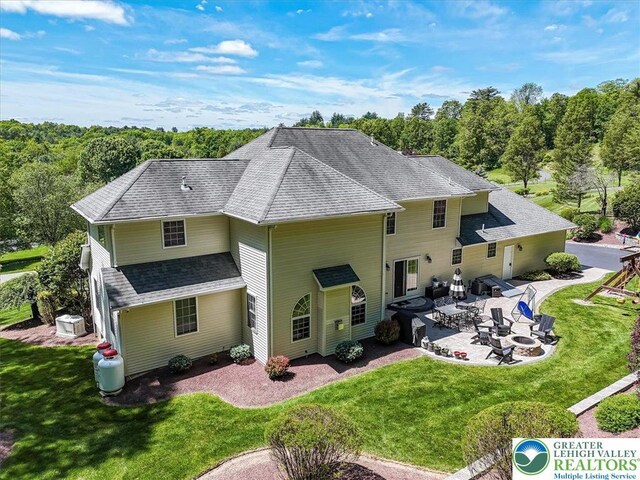 1376 Buck Ridge Dr, Hamilton Twp, PA 18360 - back of property with a patio area, a lawn, roof with shingles, and an outdoor fire pit
