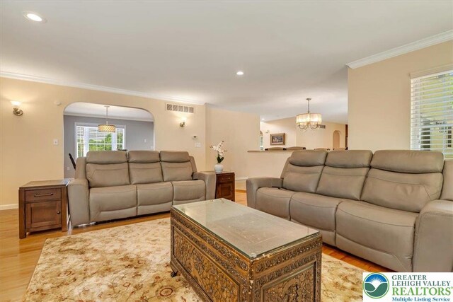 1376 Buck Ridge Dr, Hamilton Twp, PA 18360 - living room with arched walkways, light wood-type flooring, ornamental molding, a chandelier, and recessed lighting