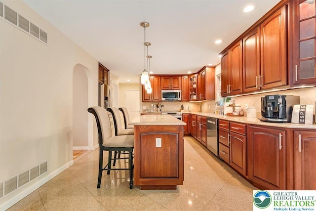 1376 Buck Ridge Dr, Hamilton Twp, PA 18360 - kitchen featuring stainless steel appliances, recessed lighting, glass insert cabinets, decorative backsplash, and a breakfast bar