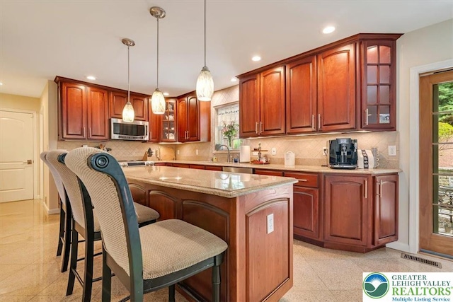 1376 Buck Ridge Dr, Hamilton Twp, PA 18360 - kitchen featuring stainless steel appliances, a center island, glass insert cabinets, recessed lighting, and decorative backsplash