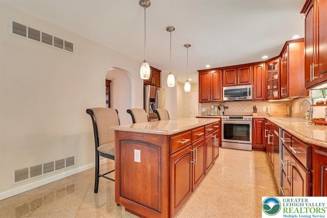 1376 Buck Ridge Dr, Hamilton Twp, PA 18360 - kitchen featuring stainless steel appliances, a kitchen bar, arched walkways, tasteful backsplash, and recessed lighting