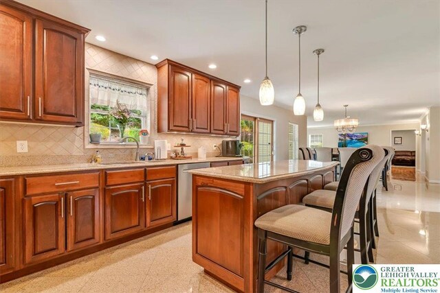 1376 Buck Ridge Dr, Hamilton Twp, PA 18360 - kitchen with dishwasher, a breakfast bar, decorative backsplash, a kitchen island, and pendant lighting
