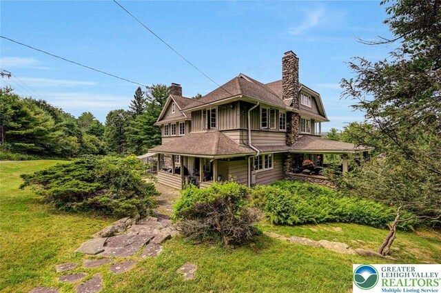 664 Griscom Rd, Barrett Twp, PA 18323 - view of front facade with a porch, a chimney, a front lawn, and board and batten siding