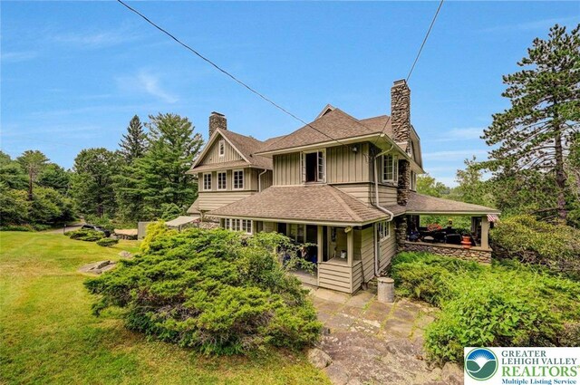 664 Griscom Rd, Barrett Twp, PA 18323 - view of front of home with a chimney, board and batten siding, a front yard, and a porch