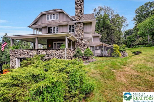664 Griscom Rd, Barrett Twp, PA 18323 - view of front of house featuring a front yard, stone siding, a chimney, and board and batten siding