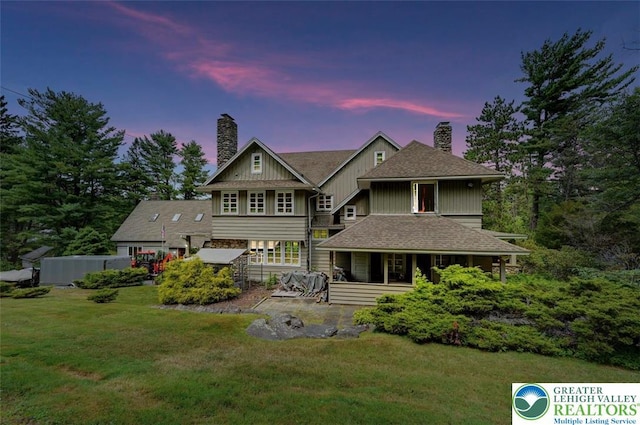664 Griscom Rd, Barrett Twp, PA 18323 - back of property at dusk with a chimney, a lawn, and a shingled roof