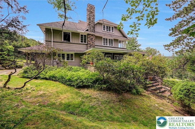 664 Griscom Rd, Barrett Twp, PA 18323 - rear view of property featuring a chimney, board and batten siding, and a lawn