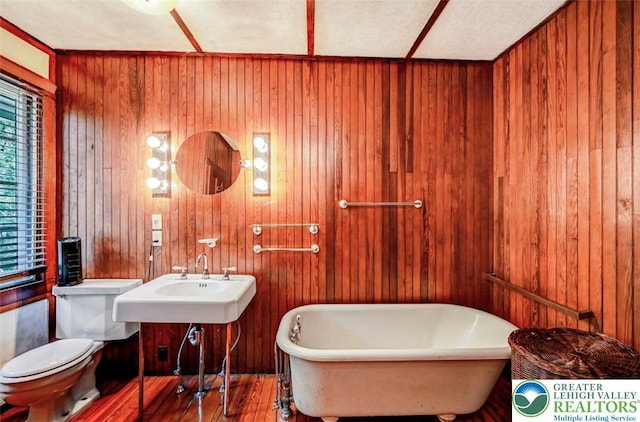 664 Griscom Rd, Barrett Twp, PA 18323 - bathroom with a freestanding bath, wooden walls, and wood finished floors