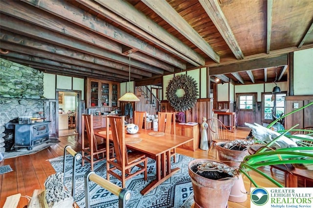 664 Griscom Rd, Barrett Twp, PA 18323 - dining room with a wood stove, wood-type flooring, stairway, a wooden ceiling with exposed beams, and wood walls