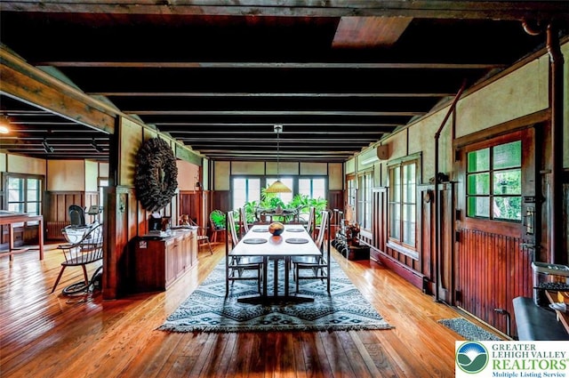 664 Griscom Rd, Barrett Twp, PA 18323 - dining room featuring wood-type flooring, plenty of natural light, beamed ceiling, and wooden walls