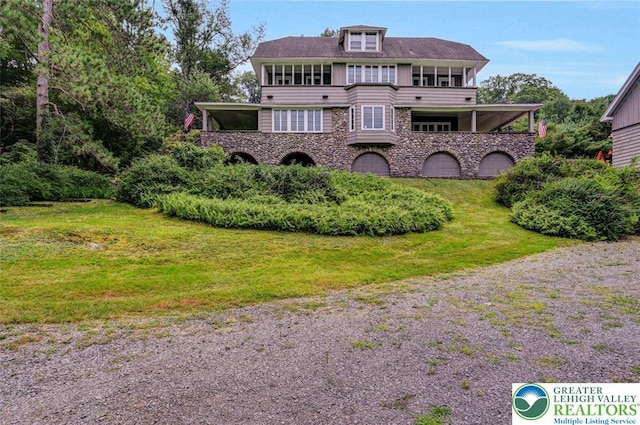 664 Griscom Rd, Barrett Twp, PA 18323 - back of house with stone siding, a balcony, and a lawn