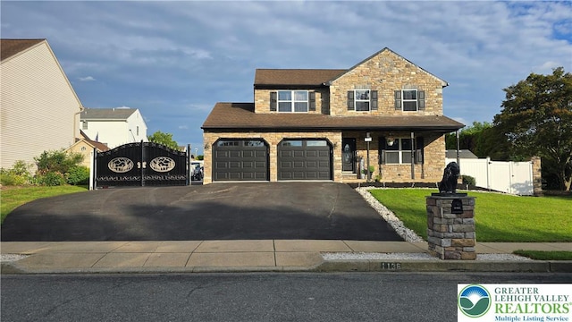 1136 Ashbourne Dr, Muhlenberg Twp, PA 19605 - craftsman house with a gate, asphalt driveway, and stone siding