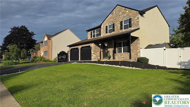 1136 Ashbourne Dr, Muhlenberg Twp, PA 19605 - view of front of home featuring stone siding, covered porch, and driveway