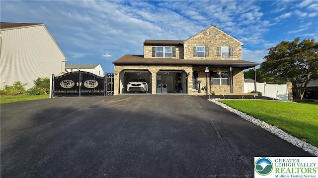 1136 Ashbourne Dr, Muhlenberg Twp, PA 19605 - view of front of home featuring a gate, stone siding, and asphalt driveway