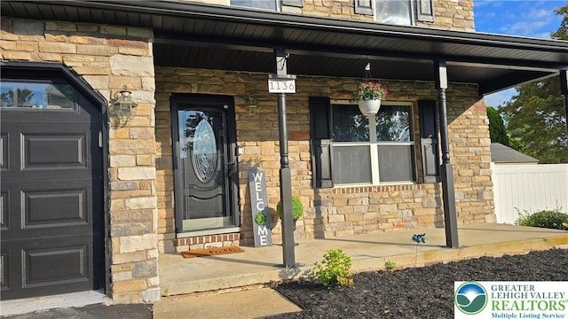 1136 Ashbourne Dr, Muhlenberg Twp, PA 19605 - view of exterior entry with stone siding and a porch