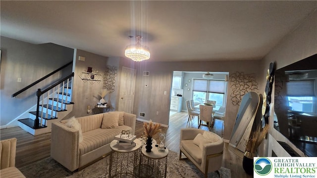 1136 Ashbourne Dr, Muhlenberg Twp, PA 19605 - living room featuring wood finished floors, stairs, and a chandelier