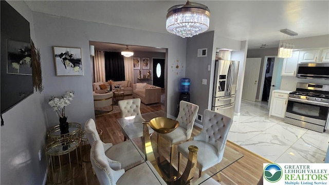 1136 Ashbourne Dr, Muhlenberg Twp, PA 19605 - dining space with a chandelier and light marble finish floors