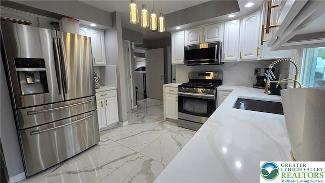 1136 Ashbourne Dr, Muhlenberg Twp, PA 19605 - kitchen with appliances with stainless steel finishes, light marble finish floors, white cabinets, light stone counters, and hanging light fixtures
