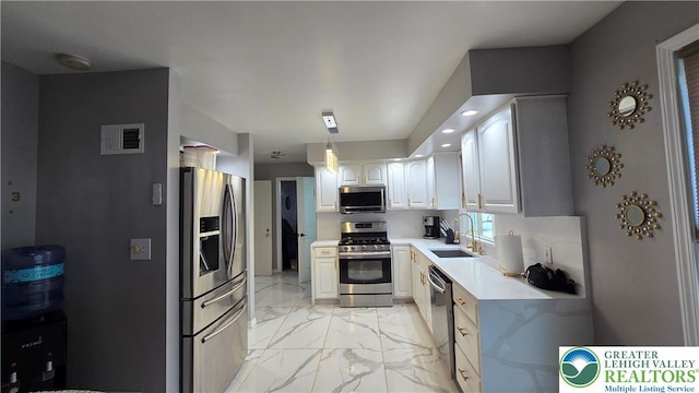 1136 Ashbourne Dr, Muhlenberg Twp, PA 19605 - kitchen with appliances with stainless steel finishes, light marble finish flooring, light countertops, white cabinets, and decorative light fixtures