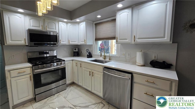1136 Ashbourne Dr, Muhlenberg Twp, PA 19605 - kitchen featuring appliances with stainless steel finishes, light marble finish floors, white cabinets, light countertops, and recessed lighting