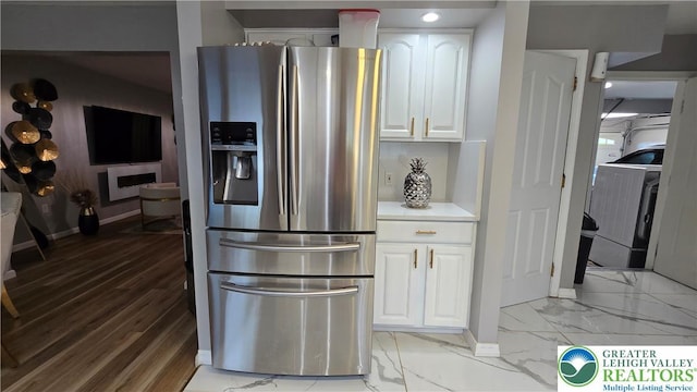 1136 Ashbourne Dr, Muhlenberg Twp, PA 19605 - kitchen with stainless steel fridge with ice dispenser, washer / clothes dryer, light marble finish flooring, white cabinets, and light countertops
