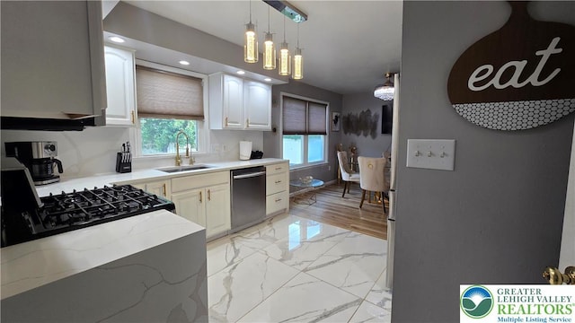 1136 Ashbourne Dr, Muhlenberg Twp, PA 19605 - kitchen with stainless steel dishwasher, light stone counters, hanging light fixtures, light marble finish floors, and recessed lighting