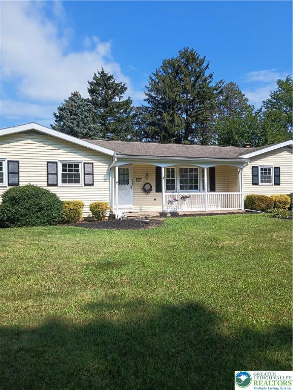 6059 Clubhouse Ln, Lower Macungie Twp, PA 18106 - ranch-style house featuring covered porch and a front yard