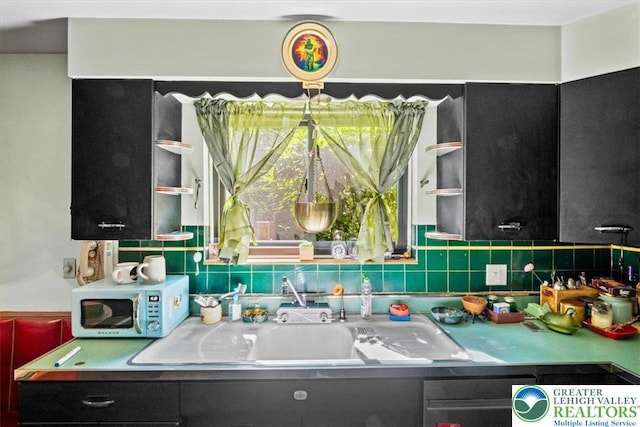 1321 W Union Blvd, Bethlehem City, PA 18018 - kitchen with stainless steel microwave, dark cabinetry, and backsplash