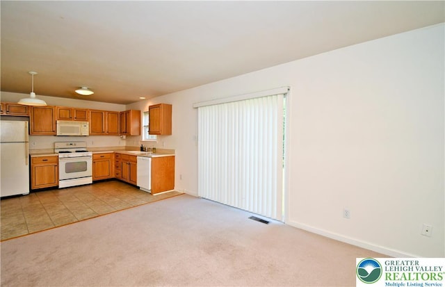 5631 Stonecroft Ln, Lower Macungie Twp, PA 18106 - kitchen featuring white appliances, light countertops, light colored carpet, and brown cabinetry