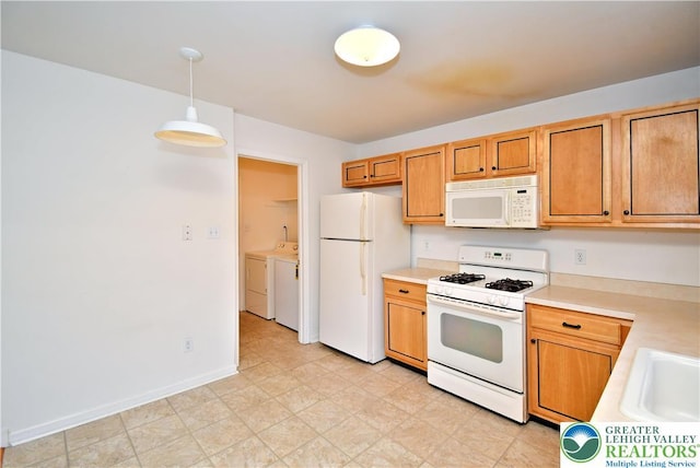 5631 Stonecroft Ln, Lower Macungie Twp, PA 18106 - kitchen with white appliances, washer and dryer, light countertops, and hanging light fixtures