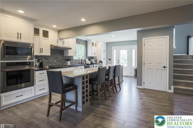 3536 New Hampshire Ave, Bethlehem Twp, PA 18045 - kitchen featuring stainless steel appliances, a breakfast bar area, white cabinets, dark wood finished floors, and recessed lighting