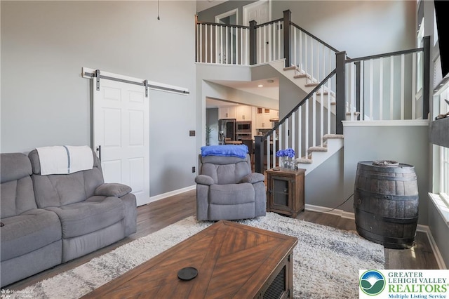 3536 New Hampshire Ave, Bethlehem Twp, PA 18045 - living room with a barn door, wood finished floors, a high ceiling, and stairs