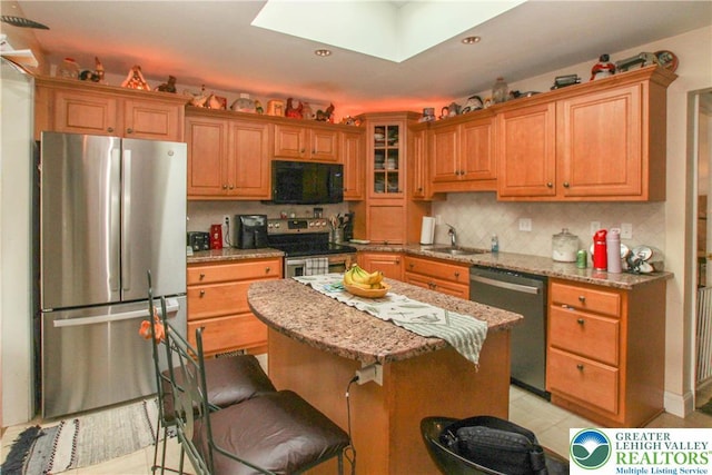 518 Bauer Rd, Moore Twp, PA 18014 - kitchen featuring stainless steel appliances, a skylight, tasteful backsplash, a center island, and glass insert cabinets