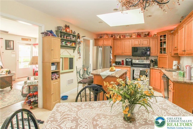 518 Bauer Rd, Moore Twp, PA 18014 - kitchen with appliances with stainless steel finishes, a center island, light stone counters, a skylight, and open shelves