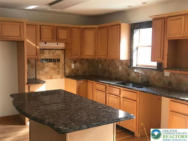 217 St Andrews Dr, Middle Smithfield Twp, PA 18324 - kitchen featuring a kitchen island, light wood-type flooring, tasteful backsplash, and dark stone countertops