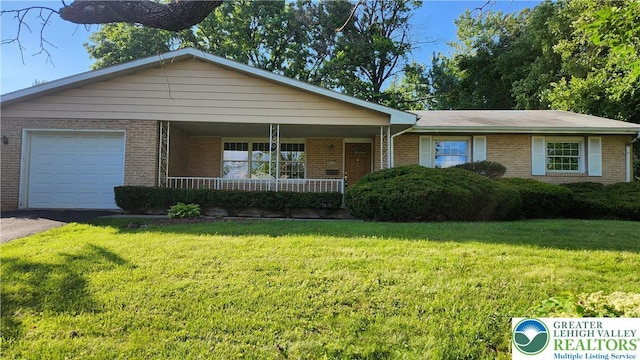 2425 Pennsylvania St, South Whitehall Twp, PA 18104 - single story home featuring a porch, an attached garage, a front lawn, and brick siding