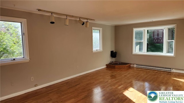 2425 Pennsylvania St, South Whitehall Twp, PA 18104 - empty room featuring a baseboard radiator, ornamental molding, plenty of natural light, wood finished floors, and track lighting