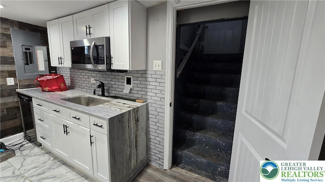 1500 Schuylkill Ave, Reading City, PA 19601 - kitchen featuring stainless steel microwave, electric panel, white cabinetry, and tasteful backsplash